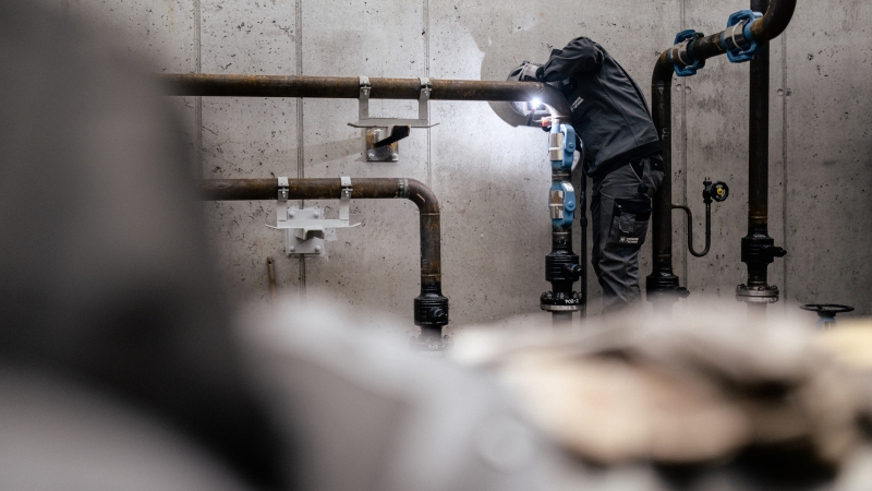 Ein HF Energietechnik Arbeiter schweißt ein Rohr